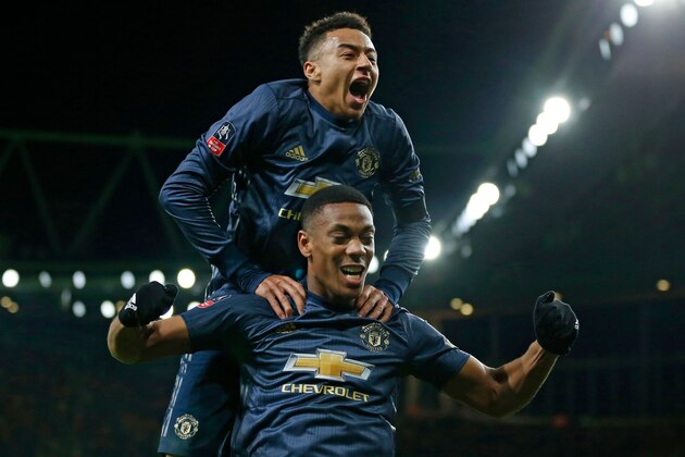 Manchester United's English midfielder Jesse Lingard celebrates by leaping onto the back of Manchester United's French striker Anthony Martial after Martial scores their third goal during the English FA Cup fourth round football match between Arsenal and Manchester United at the Emirates Stadium in London on January 25, 2019. (Photo by Ian KINGTON / IKIMAGES / AFP) / RESTRICTED TO EDITORIAL USE. No use with unauthorized audio, video, data, fixture lists, club/league logos or 'live' services. Online in-match use limited to 45 images, no video emulation. No use in betting, games or single club/league/player publications.        (Photo credit should read IAN KINGTON/AFP/Getty Images)