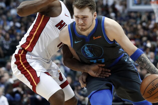 Miami Heat's Dion Waiters defends as Dallas Mavericks' Luka Doncic moves to the basket during an NBA basketball game in Dallas, Wednesday, Feb. 13, 2019. (AP Photo/Tony Gutierrez)