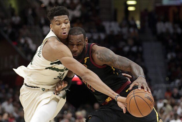 Milwaukee Bucks' Giannis Antetokounmpo, left, from Greece, knocks the ball loose from Cleveland Cavaliers' LeBron James in the first half of an NBA basketball game, Monday, March 19, 2018, in Cleveland. (AP Photo/Tony Dejak)