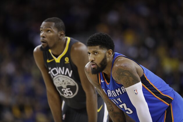 Oklahoma City Thunder's Paul George (13) stands next to Golden State Warriors' Kevin Durant (35) during the second half of an NBA basketball game Tuesday, Feb. 6, 2018, in Oakland, Calif. (AP Photo/Marcio Jose Sanchez)