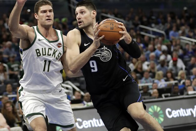 Orlando Magic's Nikola Vucevic (9) drives around Milwaukee Bucks' Brook Lopez (11) during the first half of an NBA basketball game, Saturday, Jan. 19, 2019, in Orlando, Fla. (AP Photo/John Raoux)