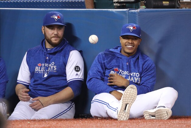 TORONTO, ON - SEPTEMBER 24: Russell Martin #55 of the Toronto Blue Jays and Marcus Stroman #6 playfully flip a baseball to each other back and forth as they watch the game from the top step of the dugout during MLB game action against the Houston Astros at Rogers Centre on September 24, 2018 in Toronto, Canada. (Photo by Tom Szczerbowski/Getty Images)