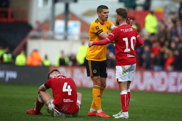 Bristol City's English defender Adam Webster (L) reacts to their defeat as Wolverhampton Wanderers' English midfielder Conor Coady (C) consoles Bristol City's English striker Matty Taylor (R) on the pitch after the English FA Cup fifth round football match between Bristol City and Wolverhampton Wanderers at Ashton Gate Stadium in Bristol, south-west England on February 17, 2019. - Wolves won the game 1-0. (Photo by GEOFF CADDICK / AFP) / RESTRICTED TO EDITORIAL USE. No use with unauthorized audio, video, data, fixture lists, club/league logos or 'live' services. Online in-match use limited to 120 images. An additional 40 images may be used in extra time. No video emulation. Social media in-match use limited to 120 images. An additional 40 images may be used in extra time. No use in betting publications, games or single club/league/player publications. /         (Photo credit should read GEOFF CADDICK/AFP/Getty Images)