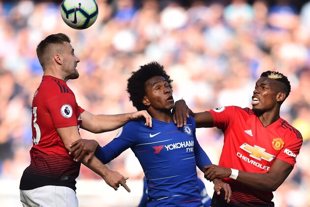 Chelsea's Brazilian midfielder Willian (C) vies with Manchester United's English defender Luke Shaw (L) and Manchester United's French midfielder Paul Pogba (R) during the English Premier League football match between Chelsea and Manchester United at Stamford Bridge in London on October 20, 2018. (Photo by Glyn KIRK / AFP) / RESTRICTED TO EDITORIAL USE. No use with unauthorized audio, video, data, fixture lists, club/league logos or 'live' services. Online in-match use limited to 120 images. An additional 40 images may be used in extra time. No video emulation. Social media in-match use limited to 120 images. An additional 40 images may be used in extra time. No use in betting publications, games or single club/league/player publications. /         (Photo credit should read GLYN KIRK/AFP/Getty Images)