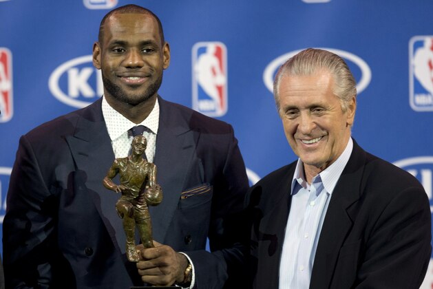 In this May 5, 2013 photo, Miami Heat NBA basketball player LeBron James, left, holds his NBA Most Valuable Player award as he poses with team president Pat Riley, in Miami. Before James makes his next decision, Riley will get a chance to convince him to stay in Miami. Two people familiar with the situation told The Associated Press late Sunday night, July 6, 2014, that James will meet with the Heat president this week before making a decision about where to play next season. (AP Photo/J Pat Carter)