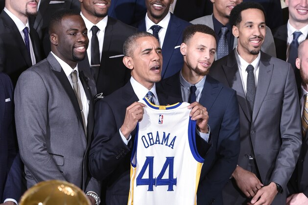US President Barack Obama holds a jersey while poseing with  forward Draymond Green (L), Golden State Warriors guard Stephen Curry (2nd R) and guard Shaun Livingston (R) during an event honoring the 2015 NBA Champion Golden State Warriors in the East Room of the White House on February 4, 2015 in Washington, DC. / AFP / MANDEL NGAN        (Photo credit should read MANDEL NGAN/AFP/Getty Images)