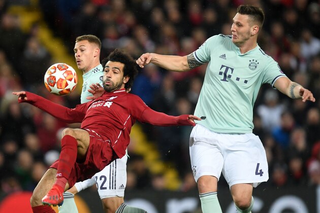 Liverpool's Egyptian midfielder Mohamed Salah (C) controls the ball under pressure from Bayern Munich's German midfielder Joshua Kimmich (L) and Bayern Munich's German defender Niklas Suele (R) during the UEFA Champions League round of 16, first leg football match between Liverpool and Bayern Munich at Anfield stadium in Liverpool, north-west England on February 19, 2019. (Photo by Christof STACHE / AFP)        (Photo credit should read CHRISTOF STACHE/AFP/Getty Images)