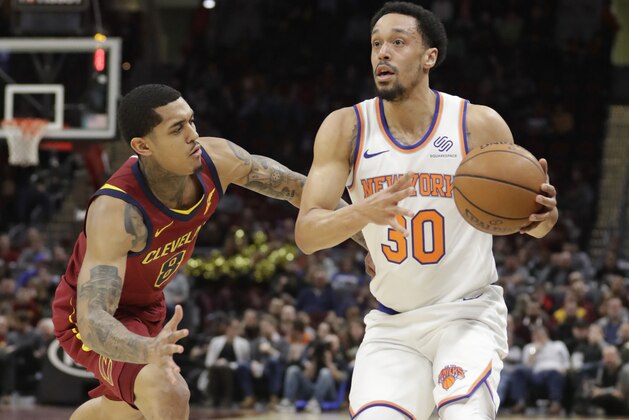 New York Knicks' John Jenkins (30) drives past Cleveland Cavaliers' Jordan Clarkson (8) in the second half of an NBA basketball game, Monday, Feb. 11, 2019, in Cleveland. (AP Photo/Tony Dejak)