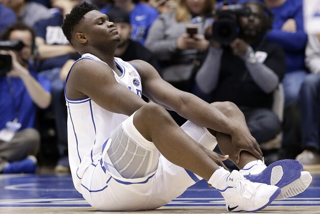 Duke's Zion Williamson sits on the floor following a injury during the first half of an NCAA college basketball game against North Carolina in Durham, N.C., Wednesday, Feb. 20, 2019. (AP Photo/Gerry Broome)