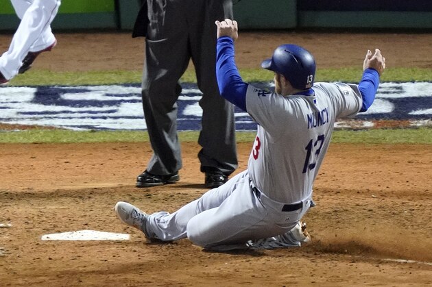 Los Angeles Dodgers Max Muncy scores on a sacrifice fly by Manny Machado during the seventh inning of Game 1 of the World Series baseball game against the Boston Red Sox Tuesday, Oct. 23, 2018, in Boston. (AP Photo/Elise Amendola)
