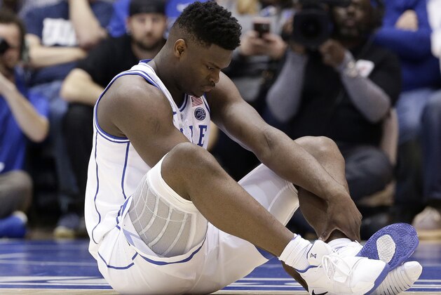 Duke's Zion Williamson sits on the floor following a injury during the first half of an NCAA college basketball game against North Carolina in Durham, N.C., Wednesday, Feb. 20, 2019. (AP Photo/Gerry Broome)