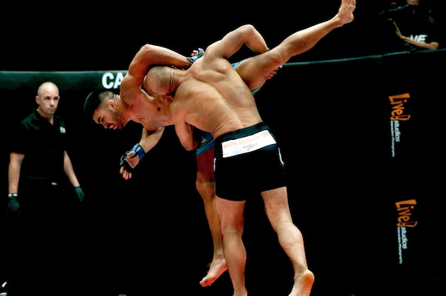 KUALA LUMPUR, MALAYSIA - MARCH 14:  Ariel Sexton of Costa Rica is thrown by Kamal Shalorus of Iran during the One FC War of Nations Lightweight Category bout  at Stadium Negara on March 14, 2014 in Kuala Lumpur, Malaysia.  (Photo by Stanley Chou/Getty Images)