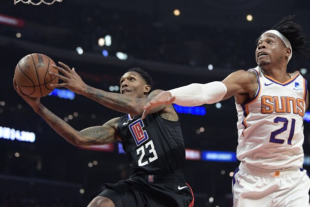 Los Angeles Clippers guard Lou Williams, left, shoots as Phoenix Suns forward Richaun Holmes defends during the first half of an NBA basketball game Wednesday, Feb. 13, 2019, in Los Angeles. (AP Photo/Mark J. Terrill)