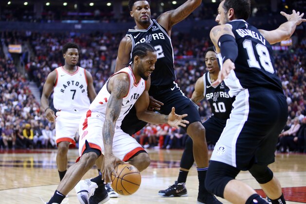 TORONTO, ON - FEBRUARY 22:  Kawhi Leonard #2 of the Toronto Raptors dribbles the ball as Rudy Gay #22 of the San Antonio Spurs defends during the first half of an NBA game at Scotiabank Arena on February 22, 2019 in Toronto, Canada.  NOTE TO USER: User expressly acknowledges and agrees that, by downloading and or using this photograph, User is consenting to the terms and conditions of the Getty Images License Agreement.  (Photo by Vaughn Ridley/Getty Images)