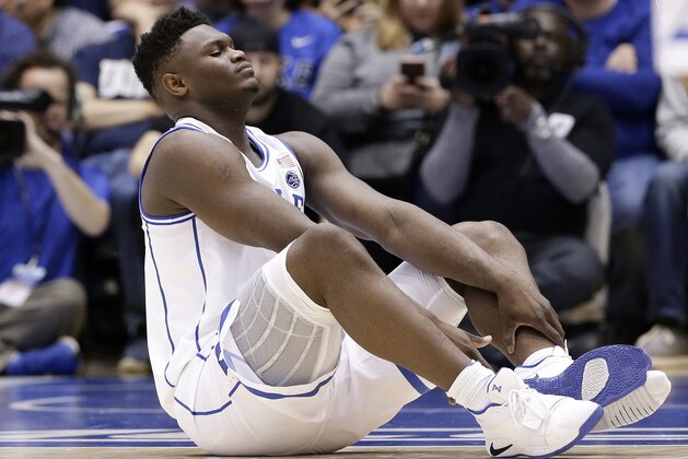 Duke's Zion Williamson sits on the floor following a injury during the first half of an NCAA college basketball game against North Carolina in Durham, N.C., Wednesday, Feb. 20, 2019. (AP Photo/Gerry Broome)