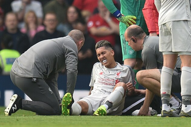 Liverpool's Brazilian midfielder Roberto Firmino gets attention on the field after taking a knock during the English Premier League football match between Manchester United and Liverpool at Old Trafford in Manchester, north west England, on February 24, 2019. (Photo by Oli SCARFF / AFP) / RESTRICTED TO EDITORIAL USE. No use with unauthorized audio, video, data, fixture lists, club/league logos or 'live' services. Online in-match use limited to 120 images. An additional 40 images may be used in extra time. No video emulation. Social media in-match use limited to 120 images. An additional 40 images may be used in extra time. No use in betting publications, games or single club/league/player publications. /         (Photo credit should read OLI SCARFF/AFP/Getty Images)