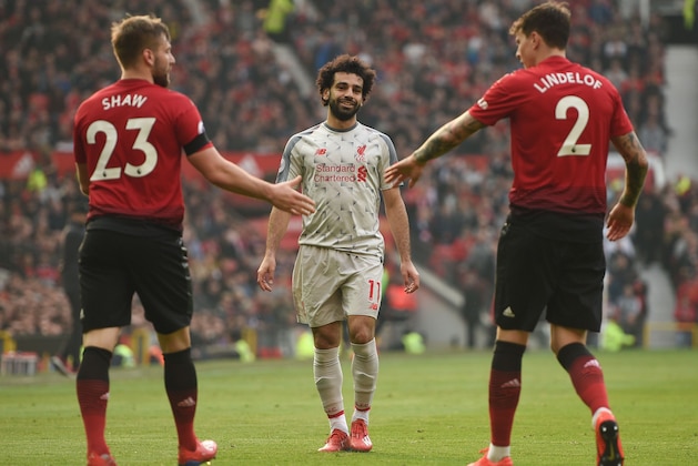 Manchester United's English defender Luke Shaw (L) shakes hands with Manchester United's Swedish defender Victor Lindelof (R) as Liverpool's Egyptian midfielder Mohamed Salah (C) looks on during the English Premier League football match between Manchester United and Liverpool at Old Trafford in Manchester, north west England, on February 24, 2019. (Photo by Oli SCARFF / AFP) / RESTRICTED TO EDITORIAL USE. No use with unauthorized audio, video, data, fixture lists, club/league logos or 'live' services. Online in-match use limited to 120 images. An additional 40 images may be used in extra time. No video emulation. Social media in-match use limited to 120 images. An additional 40 images may be used in extra time. No use in betting publications, games or single club/league/player publications. /         (Photo credit should read OLI SCARFF/AFP/Getty Images)