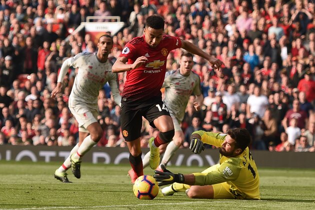 Liverpool's Brazilian goalkeeper Alisson Becker (R) makes a save from Manchester United's English midfielder Jesse Lingard (L) during the English Premier League football match between Manchester United and Liverpool at Old Trafford in Manchester, north west England, on February 24, 2019. (Photo by Oli SCARFF / AFP) / RESTRICTED TO EDITORIAL USE. No use with unauthorized audio, video, data, fixture lists, club/league logos or 'live' services. Online in-match use limited to 120 images. An additional 40 images may be used in extra time. No video emulation. Social media in-match use limited to 120 images. An additional 40 images may be used in extra time. No use in betting publications, games or single club/league/player publications. /         (Photo credit should read OLI SCARFF/AFP/Getty Images)