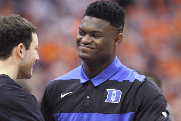 Duke's Zion Williamson, right, is greeted by a teammate on the court before the team's NCAA college basketball game against Syracuse in Syracuse, N.Y., Saturday, Feb. 23, 2019. (AP Photo/Nick Lisi)