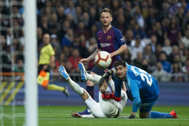 MADRID, SPAIN - MARCH 02:  Ivan Rakitic of Barcelona scores his sides first goal past Thibaut Courtois and Sergio Ramos of Real Madrid during the La Liga match between Real Madrid CF and FC Barcelona at Estadio Santiago Bernabeu on March 02, 2019 in Madrid, Spain. (Photo by Quality Sport Images/Getty Images)