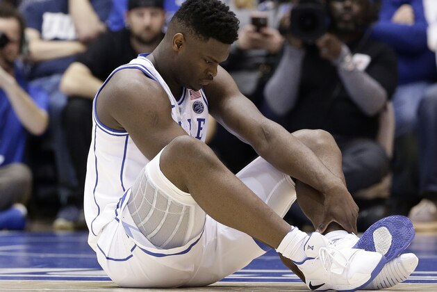 Duke's Zion Williamson sits on the floor following a injury during the first half of an NCAA college basketball game against North Carolina in Durham, N.C., Wednesday, Feb. 20, 2019. (AP Photo/Gerry Broome)