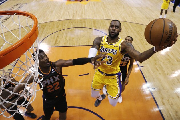 Los Angeles Lakers forward LeBron James (23) drives past Phoenix Suns center Deandre Ayton during the second half of an NBA basketball game, Saturday, March 2, 2019, in Phoenix. The Suns defeated the Lakers 118-109. (AP Photo/Rick Scuteri)