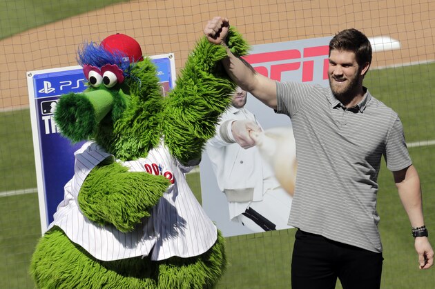 Bryce Harper stands with the Philadelphia Phillies mascot Phanatic before being introduced as a Phillies player during a news conference at the team's spring training baseball facility, Saturday, March 2, 2019, in Clearwater, Fla. Harper and the Phillies agreed to a $330 million, 13-year contract, the largest deal in baseball history. (AP Photo/Lynne Sladky)