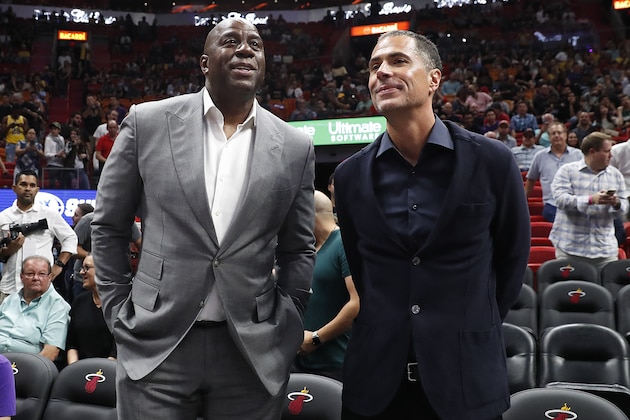 Los Angeles Lakers general manager Rob Pelinka, right, speaks with Lakers president of basketball operations Magic Johnson, left, before before an NBA basketball game against the Miami Heat Sunday, Nov. 18, 2018, in Miami, Fla. (AP Photo/Brynn Anderson)