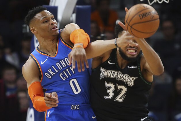 Oklahoma City Thunder's Russell Westbrook, left, knocks the ball away from Minnesota Timberwolves' Karl-Anthony Towns during the first half of an NBA basketball game Tuesday, March 5, 2019, in Minneapolis. (AP Photo/Jim Mone)