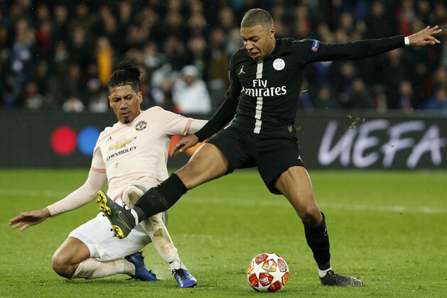 Manchester United's Chris Smalling, left, clears the ball past PSG forward Kylian Mbappe during the Champions League round of 16, 2nd leg, soccer match between Paris Saint Germain and Manchester United at the Parc des Princes stadium in Paris, France, Wednesday, March. 6, 2019. (AP Photo/Thibault Camus)