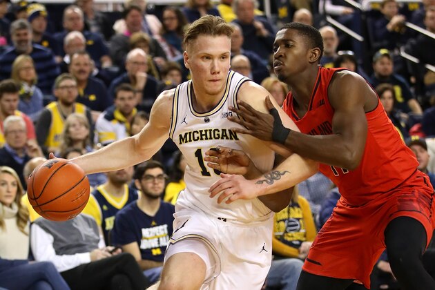 ANN ARBOR, MICHIGAN - FEBRUARY 16:   Ignas Brazdeikis #13 of the Michigan Wolverines drives around Darryl Morsell #11 of the Maryland Terrapins during the first period at Crisler Arena on February 16, 2019 in Ann Arbor, Michigan. (Photo by Gregory Shamus/Getty Images)