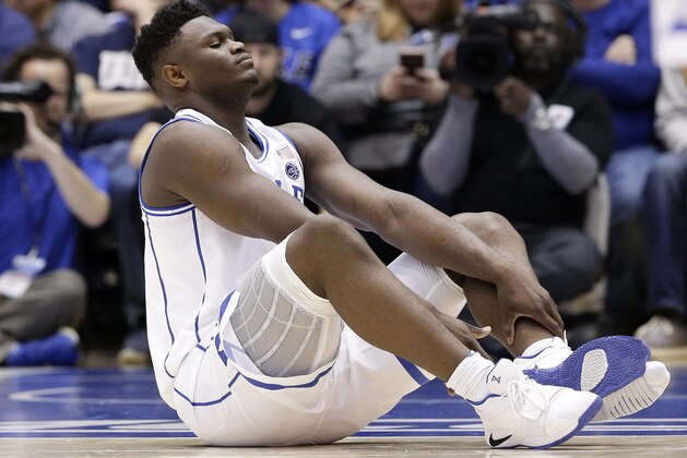Duke's Zion Williamson sits on the floor following a injury during the first half of an NCAA college basketball game against North Carolina in Durham, N.C., Wednesday, Feb. 20, 2019. (AP Photo/Gerry Broome)