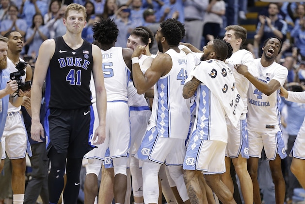 North Carolina players celebrate while Duke's Jack White (41) walks away following an NCAA college basketball game in Chapel Hill, N.C., Saturday, March 9, 2019. North Carolina won 79-70. (AP Photo/Gerry Broome)