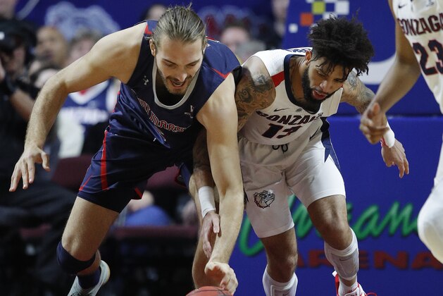 St. Mary's Jock Perry, left, and Gonzaga's Josh Perkins scramble for the ball during the first half of an NCAA college basketball game for the West Coast Conference men's tournament title, Tuesday, March 12, 2019, in Las Vegas. (AP Photo/John Locher)