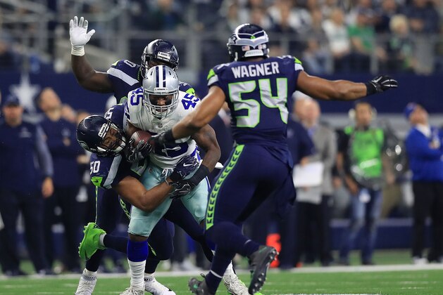 ARLINGTON, TX - DECEMBER 24:  K.J. Wright #50 of the Seattle Seahawks tackles Rod Smith #45 of the Dallas Cowboys in the second quarter of a football game at AT&T Stadium on December 24, 2017 in Arlington, Texas.  (Photo by Ronald Martinez/Getty Images)