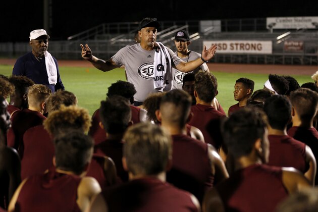 Head Coach Willis May speaks with members of the Marjory Stoneman Douglas High School football team as they started their first practice for a new season just after midnight on Monday, July 30, 2018, in Parkland, Fla. The players, their school, and community still grieves for the 17 lives lost at the school on Feb. 14. (AP Photo/Joe Skipper)