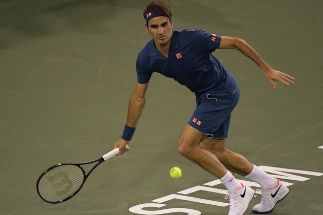Roger Federer, of Switzerland, returns a shot to Stan Wawrinka at the BNP Paribas Open tennis tournament Tuesday, March 12, 2019 in Indian Wells, Calif. (AP Photo/Mark J. Terrill)