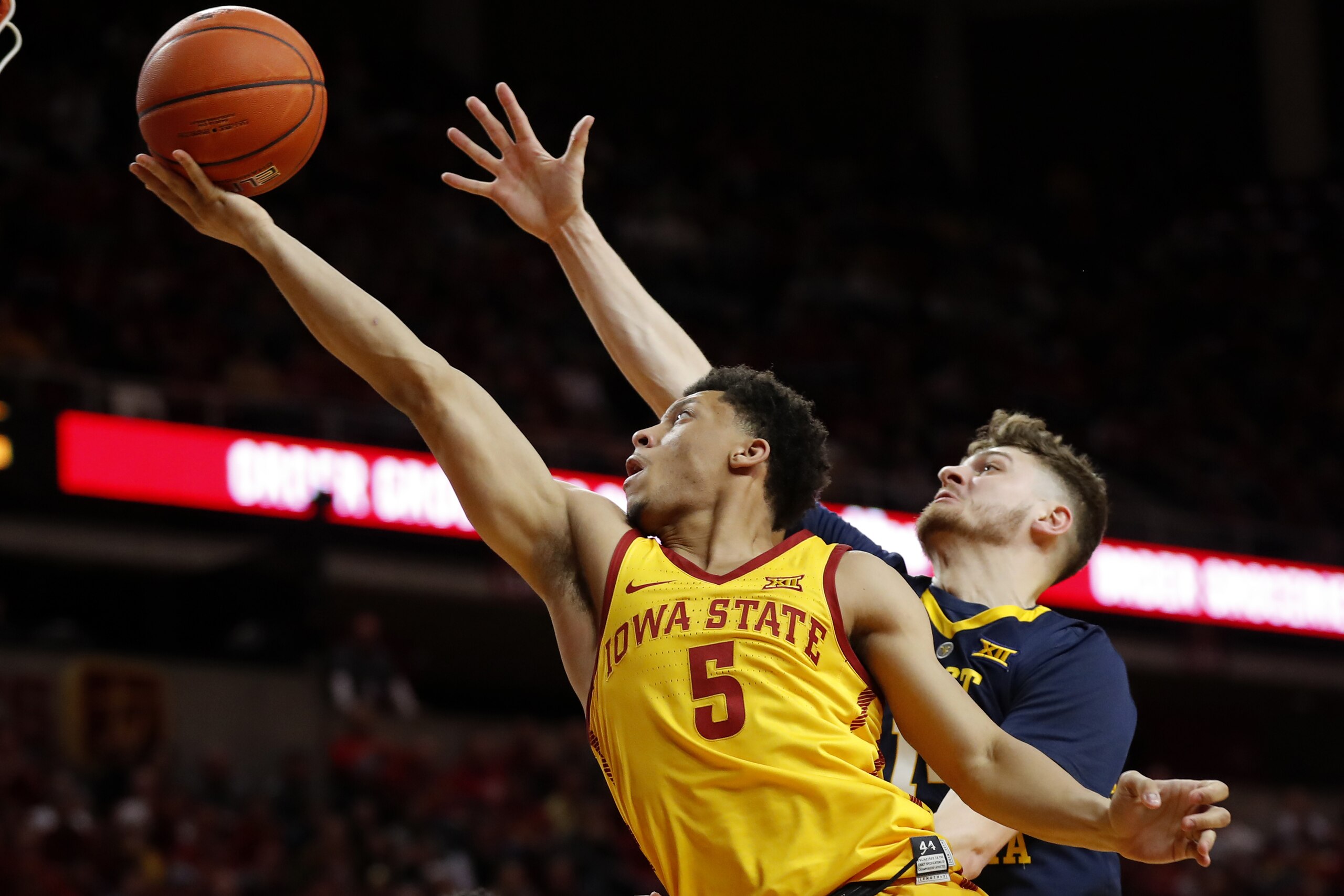 Iowa State guard Lindell Wigginton (5) drives to the basket past West Virginia guard Chase Harler during the second half of an NCAA college basketball game Wednesday, Jan. 30, 2019, in Ames, Iowa. (AP Photo/Charlie Neibergall)