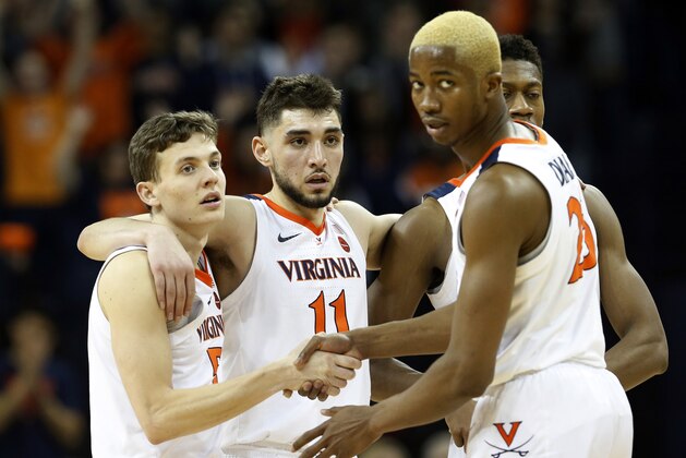 Virginia guard Kyle Guy (5), Ty Jerome (11) and forward Mamadi Diakite (25) watch a foul shot during the second half of an NCAA college basketball game against Louisville in Charlottesville, Va., Saturday, March 9, 2019. (AP Photo/Steve Helber) Virginia guard Kyle Guy (5), Ty Jerome (11) and forward Mamadi Diakite (25) watch a foul shot during the second half of an NCAA college basketball game against Louisville in Charlottesville, Va., Saturday, March 9, 2019. (AP Photo/Steve Helber)