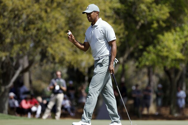 Tiger Woods holds up his golf ball after putting out on the third hole during the first round of The Players Championship golf tournament Thursday, March 14, 2019, in Ponte Vedra Beach, Fla. (AP Photo/Gerald Herbert)