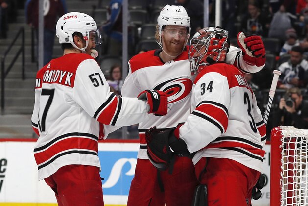 From left, Carolina Hurricanes defensemen Trevor van Riemsdyk, Dougie Hamilton and goaltender Petr Mrazek celebrate as time runs out in the third period of an NHL hockey game against the Colorado Avalanche, Monday, March 11, 2019, in Denver. Carolina won 3-0. (AP Photo/David Zalubowski)