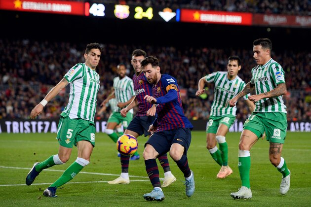 TOPSHOT - Barcelona's Argentinian forward Lionel Messi (C) vies with Real Betis' Spanish defender Marc Bartra (L) during the Spanish league football match between FC Barcelona and Real Betis at the Camp Nou stadium in Barcelona on November 11, 2018. (Photo by Josep LAGO / AFP)        (Photo credit should read JOSEP LAGO/AFP/Getty Images)