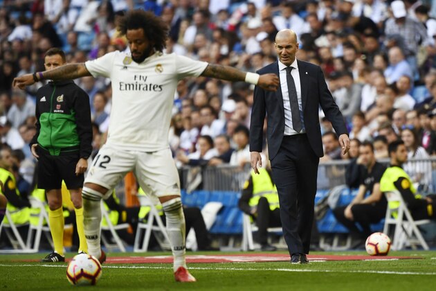 Real Madrid's French coach Zinedine Zidane (R) looks at Real Madrid's Brazilian defender Marcelo controlling the ball during the Spanish league football match between Real Madrid CF and RC Celta de Vigo at the Santiago Bernabeu stadium in Madrid on March 16, 2019. (Photo by GABRIEL BOUYS / AFP)        (Photo credit should read GABRIEL BOUYS/AFP/Getty Images)