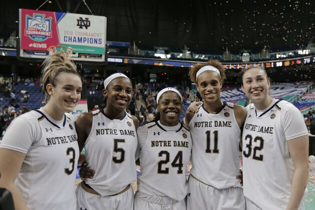 Notre Dame players Marina Mabrey (3), Jackie Young (5), Arike Ogunbowale (24), Brianna Turner (11) and Jessica Shepard (32) pose for a photo after their team defeated Louisville in an NCAA college basketball game in the championship of the Atlantic Coast Conference women's tournament in Greensboro, N.C., Sunday, March 10, 2019. (AP Photo/Chuck Burton)