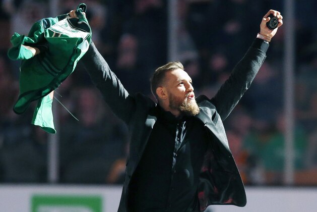 Mixed martial arts fighter and boxer Conor McGregor salutes the crowd before making the ceremonial puck drop at an NHL hockey game between the Boston Bruins and the Columbus Blue Jackets in Boston, Saturday, March 16, 2019. (AP Photo/Michael Dwyer)