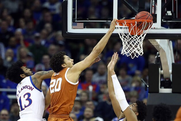 KANSAS CITY, MISSOURI - MARCH 14:  Jericho Sims #20 of the Texas Longhorns dunks as K.J. Lawson #13 of the Kansas Jayhawks defends during the quarterfinal game of the Big 12 Basketball Tournament at Sprint Center on March 14, 2019 in Kansas City, Missouri. (Photo by Jamie Squire/Getty Images)