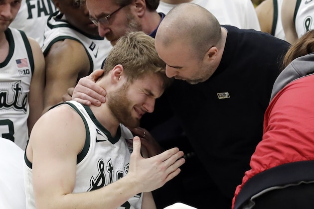 A medical personnel took talks to Michigan State's Kyle Ahrens, left, as Ahrens was the taken out of the court for injury during the first half of an NCAA college basketball championship game against Michigan in the Big Ten Conference tournament, Sunday, March 17, 2019, in Chicago. (AP Photo/Nam Y. Huh)