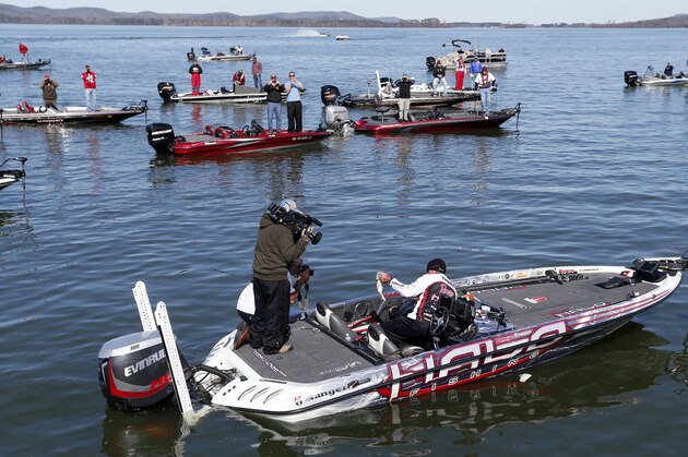 Randall Tharp, Port Saint Joe, Fla., holds up a bass for spectators following him on the second day of the Bassmaster Classic, Saturday, Feb. 22, 2014, in Guntersville, Ala. Tharp was bumped from first to second by 1 ounce by Edwin Evers, Talala, Okla. The field will be cut to the top 25 anglers for the final day of competition. (AP Photo/Hal Yeager)