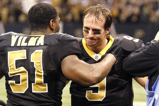 FILE - In this Dec. 26, 2011, file photo, New Orleans Saints quarterback Drew Brees (9) celebrates with linebacker Jonathan Vilma (51) after breaking Dan Marino's all-time season passing record in the fourth quarter of an NFL football game against the Atlanta Falcons in New Orleans. Brees defended Vilma in a court document filed Saturday, july 21, 2012, to support Vilma's fight against the NFL over his season-long suspension.  The affidavit was entered in New Orleans federal court as evidence for Vilma's motion to dismiss the 2012 suspension imposed by NFL Commissioner Roger Goodell, for the linebacker's alleged involvement in a program offering bonuses to players who injure opponents.  (AP Photo/Bill Haber, File)