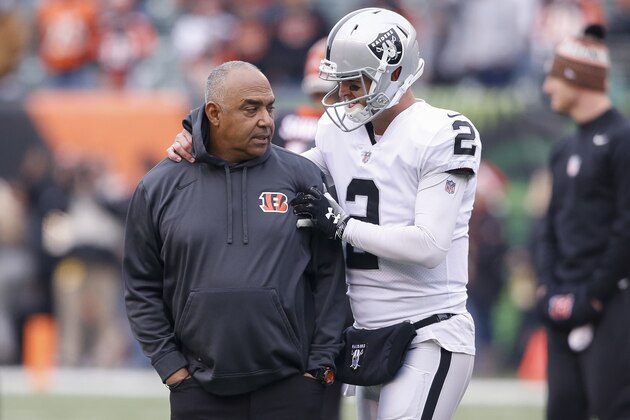 Cincinnati Bengals head coach Marvin Lewis, left, meets with Oakland Raiders quarterback AJ McCarron, right, during practice before an NFL football game, Sunday, Dec. 16, 2018, in Cincinnati. (AP Photo/Gary Landers)